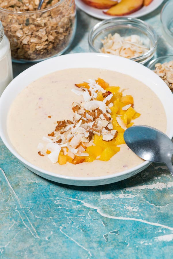 Healthy Smoothie Bowl with Mango, Coconut and Nuts for Breakfast