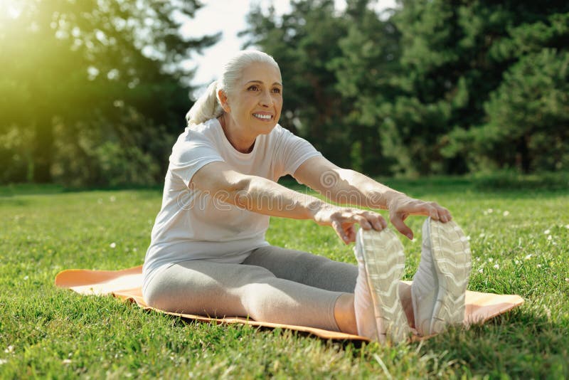 Joyful Elderly Lady Stretching Her Back in Park Stock Image - Image of ...