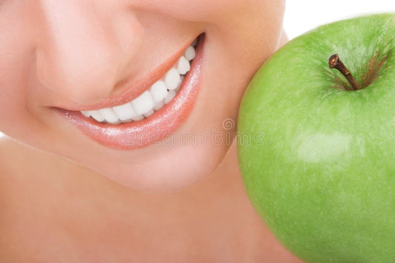 Healthy teeth and green apple. Smiling woman mouth with great white teeth. Close up. Beauty and dental health. Pretty woman