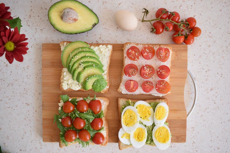 Healthy Toast for Breakfast with Avocado, Eggs, Tomatoes, Arugula Etc