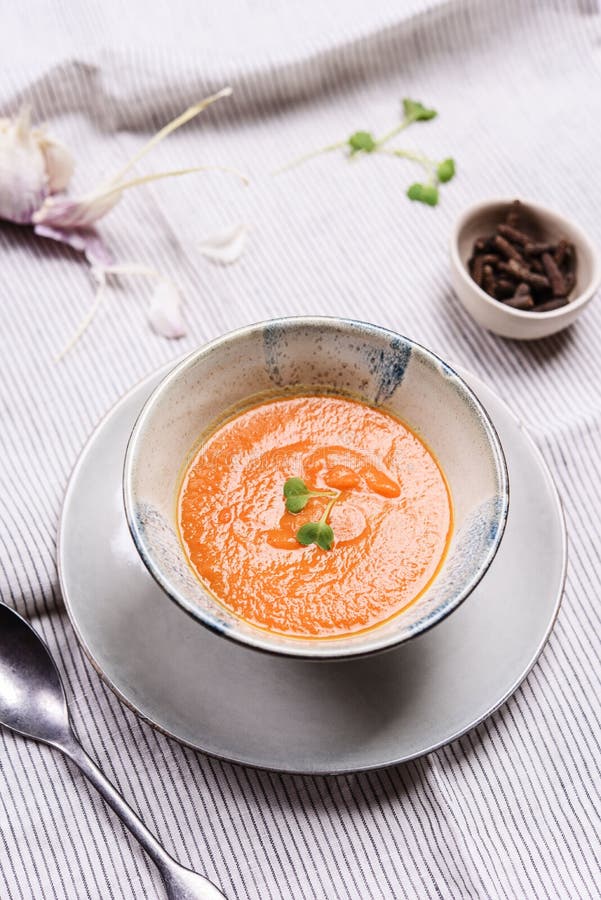 Healthy Vegetable Cream Soup in a bowl. Served with microgreen on white striped linen tablecloth. Vertical composition. Selective focus royalty free stock photos Healthy Vegetable Cream Soup in a bowl. Served with microgreen on white striped linen tablecloth. Vertical composition. Selective focus royalty free stock photos
