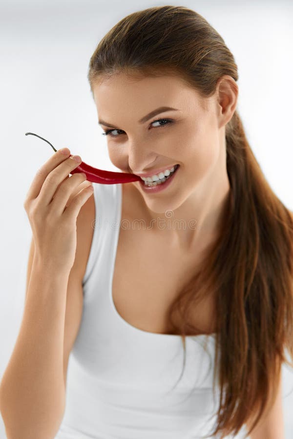 Healthy Woman Eating Spicy Red Chili Pepper. Diet, Food Concept.