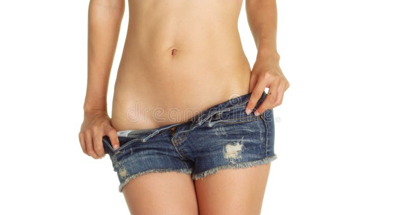 Healthy woman taking off her denim shorts. 