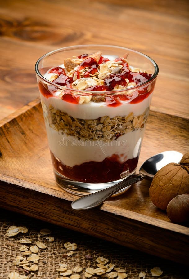 Healthy Yogurt Dessert with Muesli, Nuts and Raspberry Jam. Stock Photo