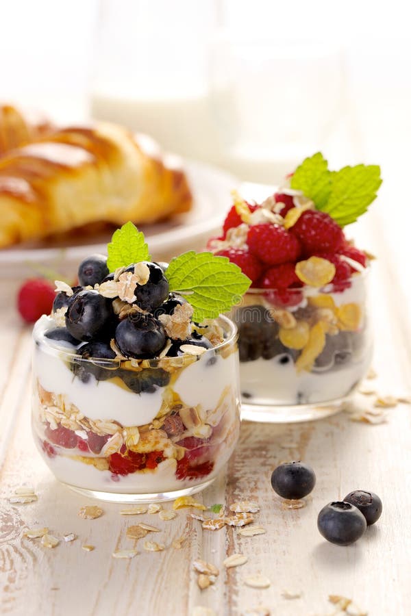 Healthy yogurt parfait with fresh organic raspberries, blueberries and granola