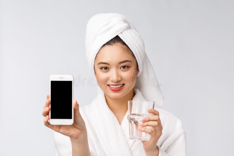 Healthy young beautiful woman drinking water, beauty face natural makeup with holding mobile phone, isolated over white