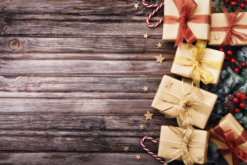 Heap of Christmas gifts or presents with holiday decorations and snowy fir tree on wooden table top view stock images Heap of Christmas gifts or presents with holiday decorations and snowy fir tree on wooden table top view stock images