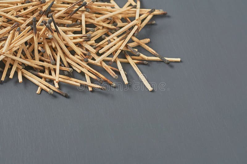 Heap of many used matchsticks with burnt sulfur on dark concrete table on kitchen
