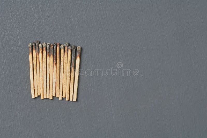 Heap of many used matchsticks with burnt sulfur on dark concrete table on kitchen. Space for text