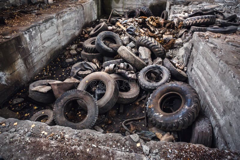 Heap of old car junk tires, used truck rubbish wheels, industrial garbage in abandoned factory royalty free stock photography