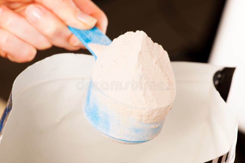 Heaped messende Schaufel des Molkeproteinpulvers mit Schokolade lizenzfreie stockfotografie Heaped messende Schaufel des Molkeproteinpulvers mit Schokolade lizenzfreie stockfotografie