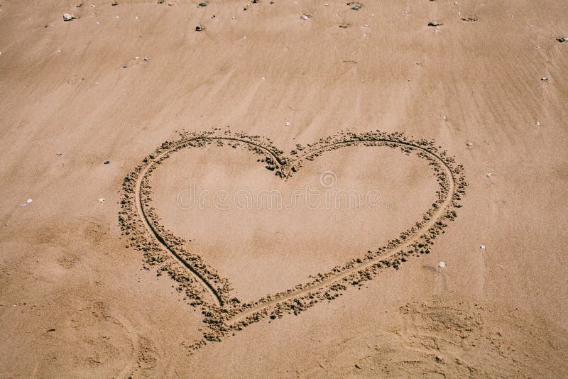 Heart drawn in the sand. Beach background with heart drawing. Heart shape love symbol as background. stock images Heart drawn in the sand. Beach background with heart drawing. Heart shape love symbol as background. stock images