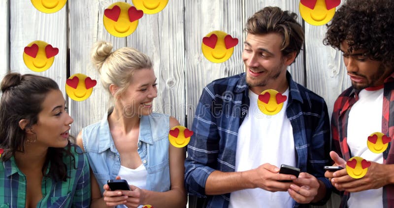 Heart eyes face emojis floating against group of friends using smartphones