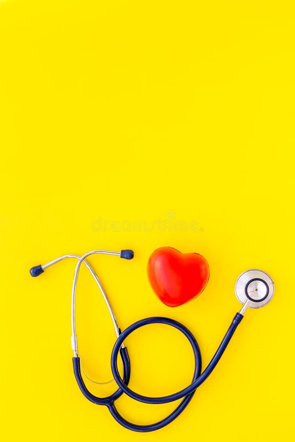 Heart health, health care concept. Stethoscope near rubber heart on yellow background top view copy space. Heart health, health care concept. Stethoscope near royalty free stock image Heart health, health care concept. Stethoscope near rubber heart on yellow background top view copy space. Heart health, health care concept. Stethoscope near royalty free stock image