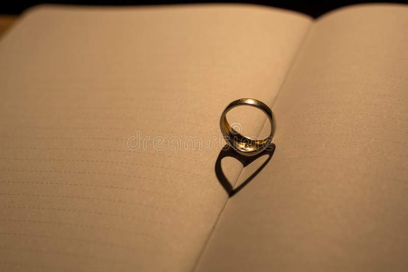 A heart made from the shadow of a ring on a blank book with line stock photos