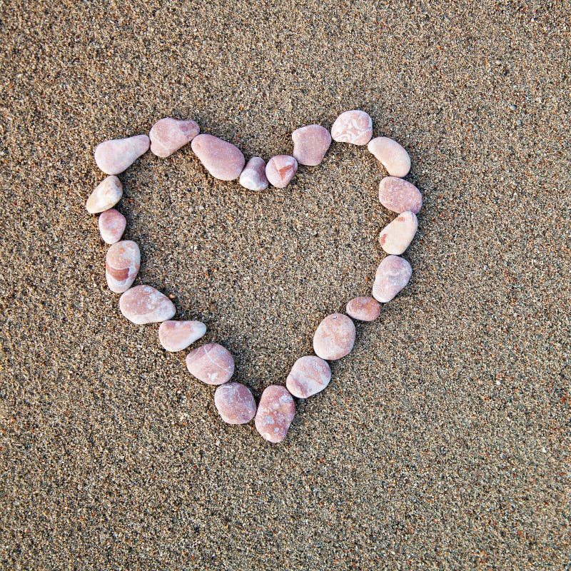 Heart of pebbles inlaid on a background of sand