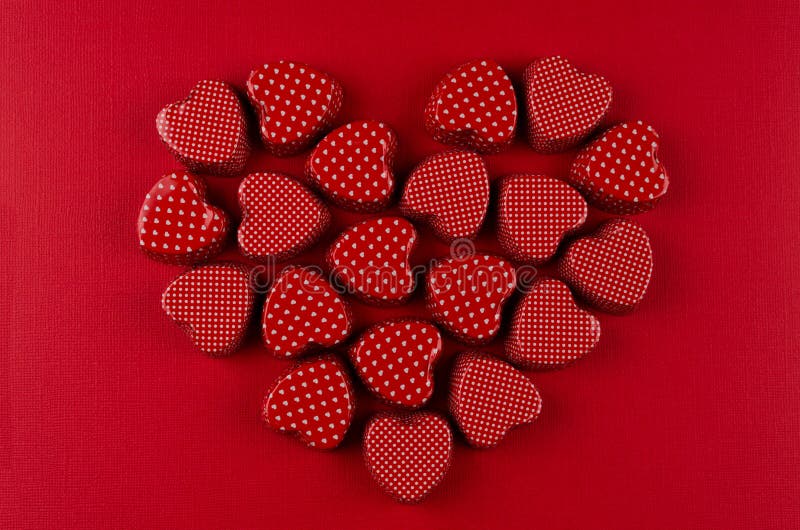 Heart of red candy hearts on deep red paper background. Valentine day card.