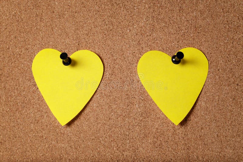 Yellow heart shape sticky notes on cork board