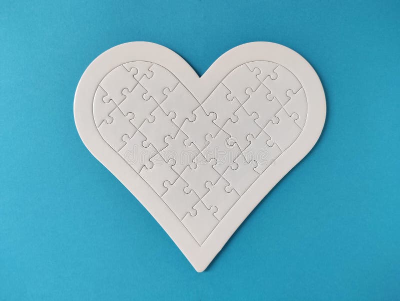 Heart Shaped Blank White Jigsaw Puzzle on Blue Background Stock Photo