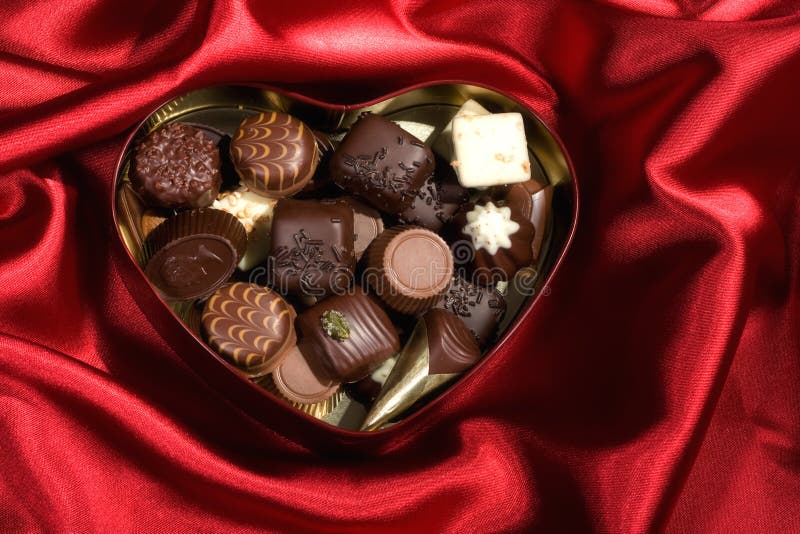 Heart Shaped Box of Candy on red satin background