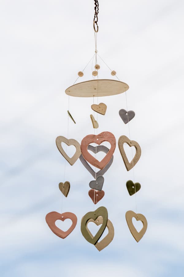 Heart shaped ceramic wind mobile hanging with defocused blue sky