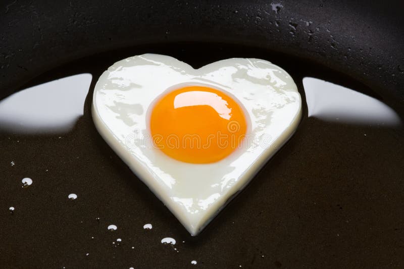 Heart shaped egg cooking in a frying pan. Frying pan stock images, royalty-free photos and pictures
