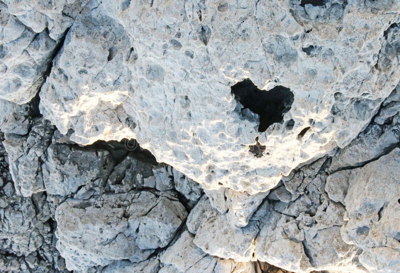 Heart shaped hole in a white stone textured wall stock photo Heart shaped hole in a white stone textured wall stock photo