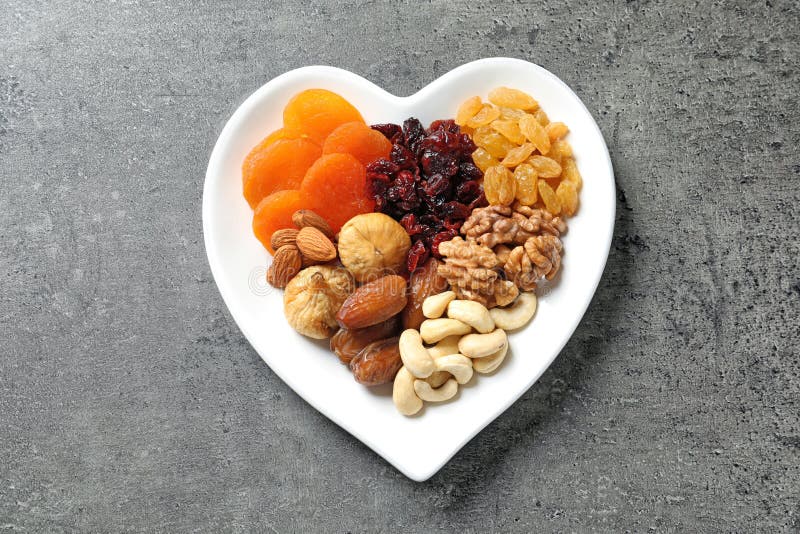 Heart Shaped Plate with Different Dried Fruits and Nuts on Table Stock