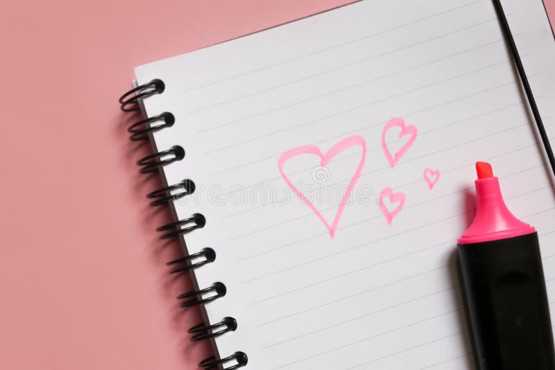 heart sign on notepad and pink marker on pink background, a love note using a pink marker, valentine& x27;s day