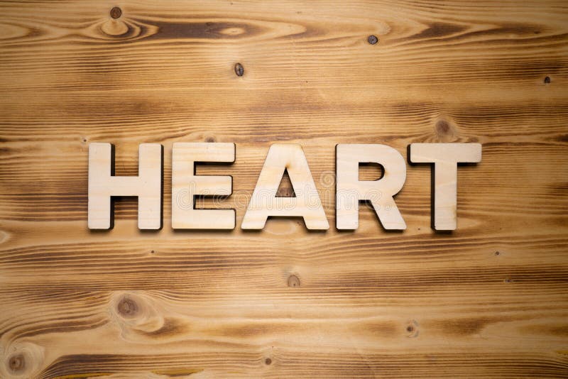 HEART word made with building blocks on wooden board.