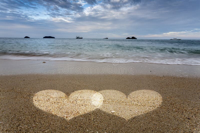 Hearts Light in Sand on Ocean Beach.