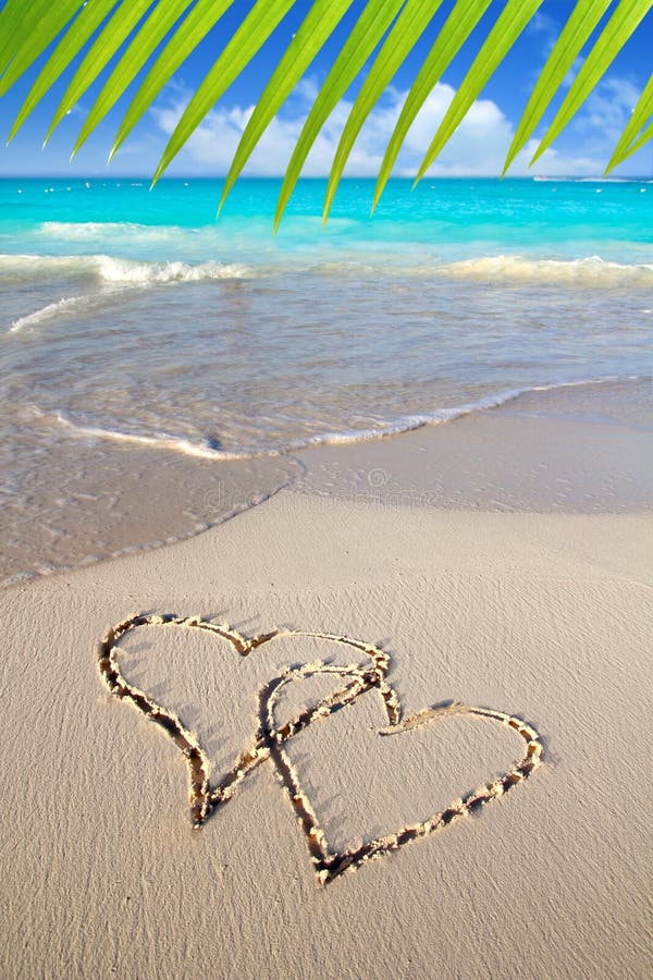 Hearts in love written in Caribbean beach sand