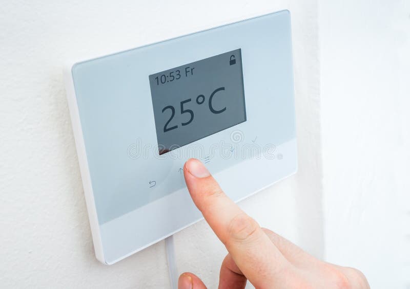Heating concept. Hand is adjusting temperature in room on digital thermostat control. stock photo Heating concept. Hand is adjusting temperature in room on digital thermostat control. stock photo