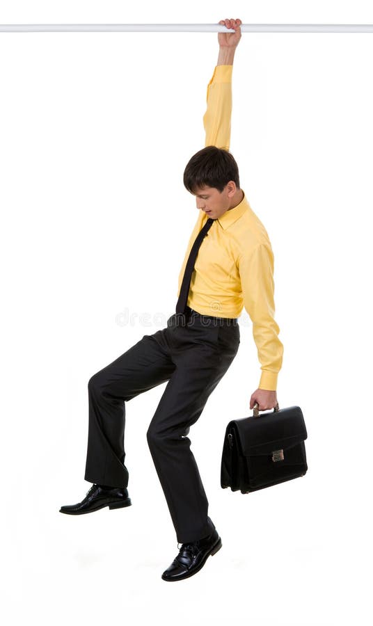 Creative image of frustrated businessman holding by horizontal bar with briefcase in another hand. Male hand holding businessman stock images, royalty-free photos and pictures