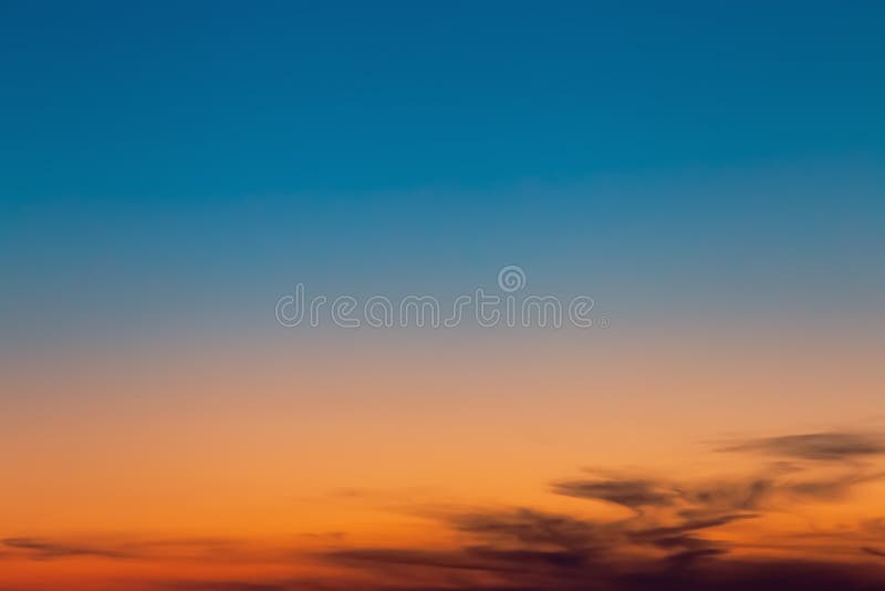 Heavenly landscape. Abstract natural background with dramatic sunny sky at sunset or dawn with beautiful clouds of orange and blue