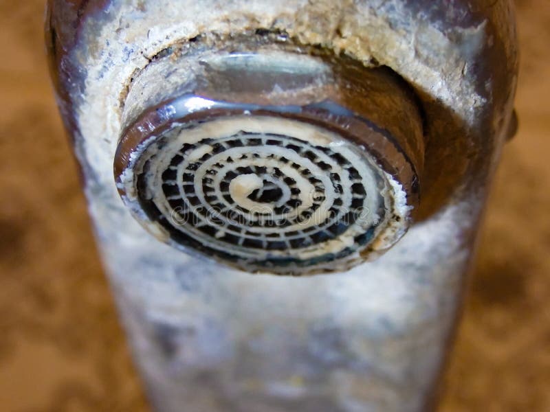 Heavily calcified faucet on a hand basin. Hard water flows from an old tap aerator. Limescale, calcified shower water tap with royalty free stock photos