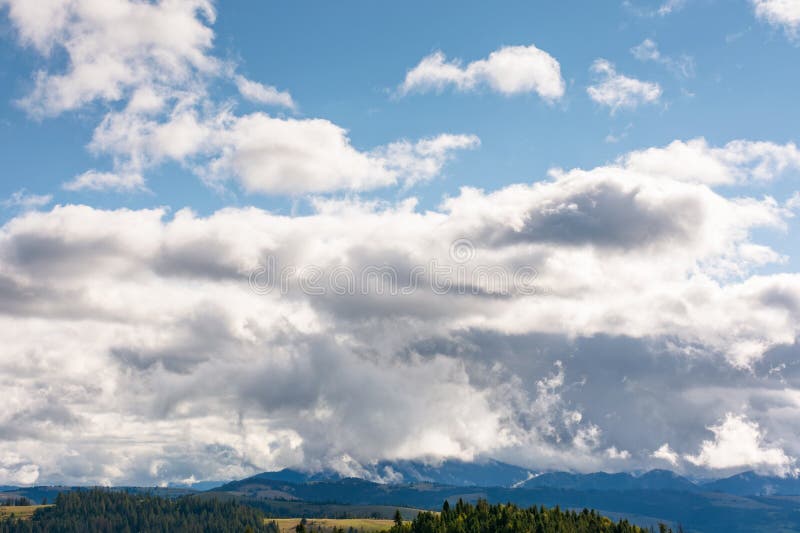 Heavy clouds on a blue sky above mountains september stock image