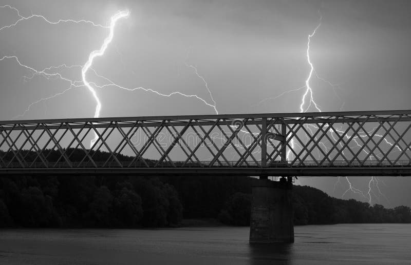 Heavy clouds bringing thunder, lightnings and storm over bridge royalty free stock photo