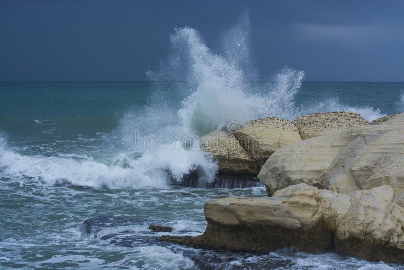 Heavy clouds with stormy waves beating against rocks and cliffs stock photos