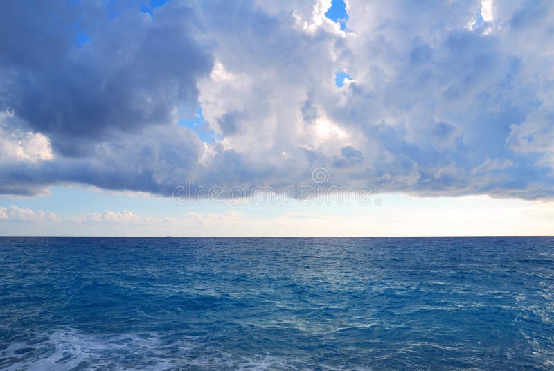Heavy clouds and vast deep blue sea royalty free stock image