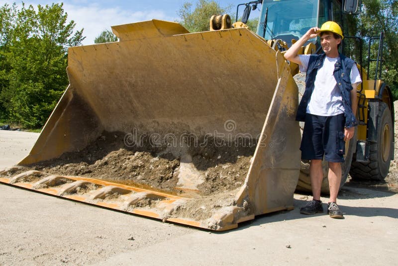 Un operatore di attrezzature pesanti in piedi fuori, sul luogo di lavoro.