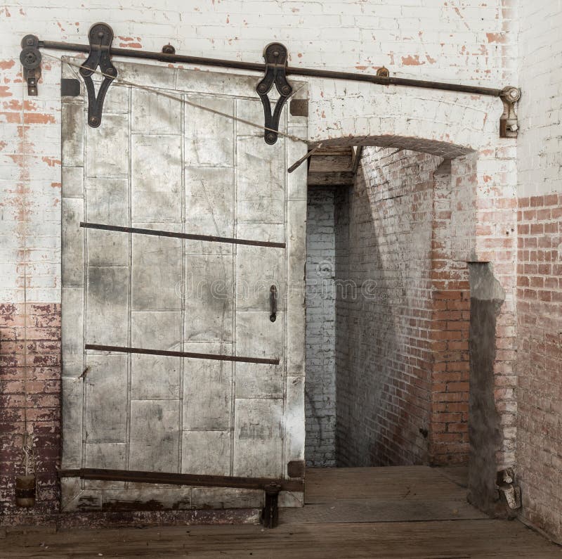 Sliding heavy industrial metal door in old warehouse