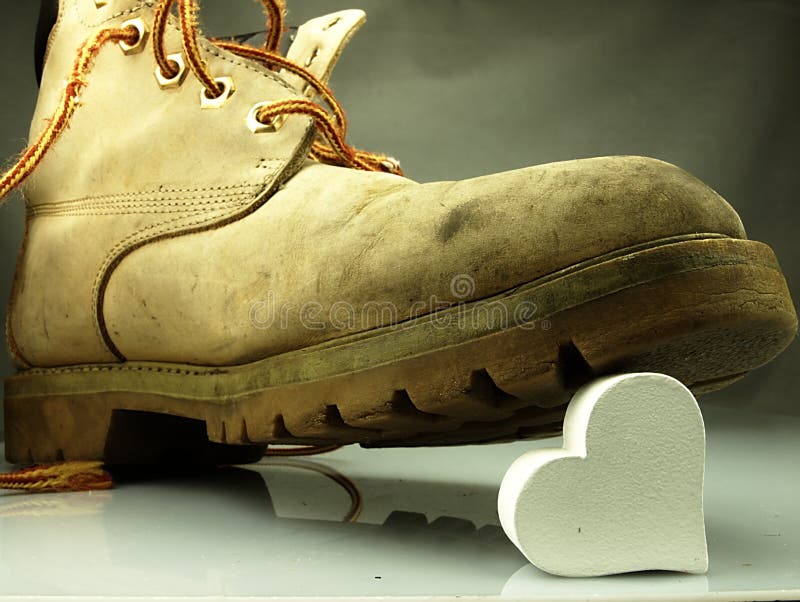 Old military boots, very heavy trampling a delicate white heart. Old military boots, very heavy trampling a delicate white heart.