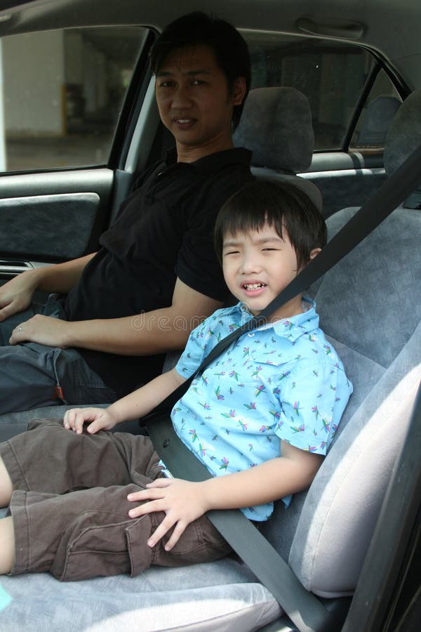 Hebilla del muchacho y del hombre encima del cinturón de seguridad