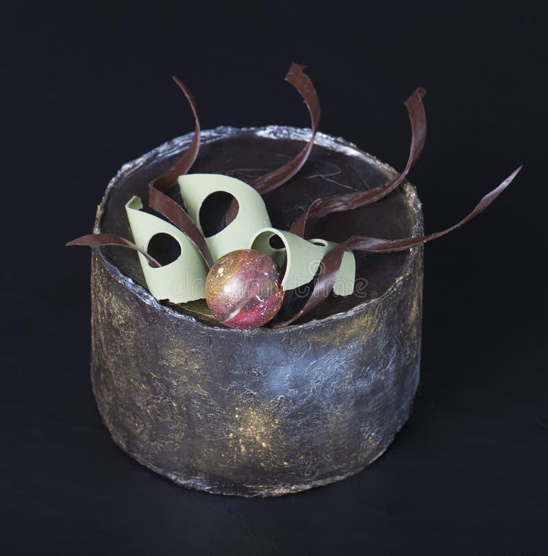 Hecho a mano de la torta de chocolate adornado maravillosamente en un fondo oscuro Foco selectivo foto de archivo Hecho a mano de la torta de chocolate adornado maravillosamente en un fondo oscuro Foco selectivo foto de archivo