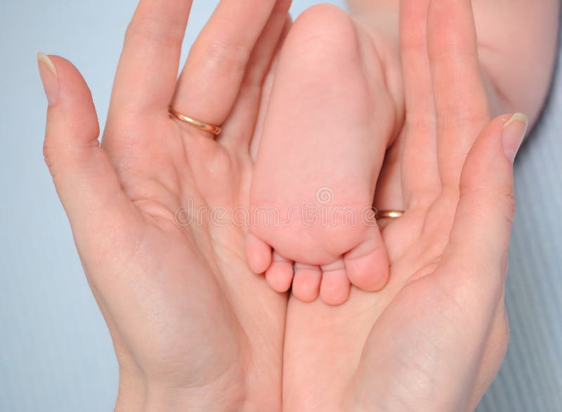 Heel of the baby in hands of mum