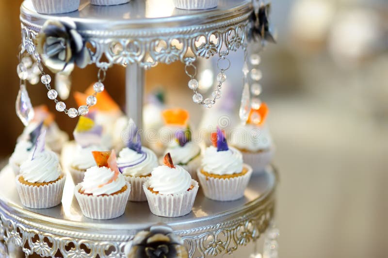 Heerlijk kleurrijk huwelijk cupcakes met bloem en vlinder en mooie verglaasde cake