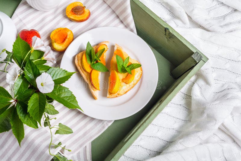 Heerlijk toostsbrood met eigengemaakte abrikozenjam en bloemen van winde stock foto Heerlijk toostsbrood met eigengemaakte abrikozenjam en bloemen van winde stock foto