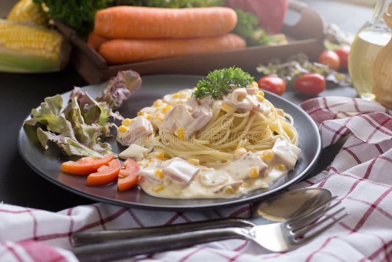 Heerlijke deegwarencarbonara met bacon en parmezaanse kaas in een zwarte boog royalty-vrije stock afbeelding Heerlijke deegwarencarbonara met bacon en parmezaanse kaas in een zwarte boog royalty-vrije stock afbeelding