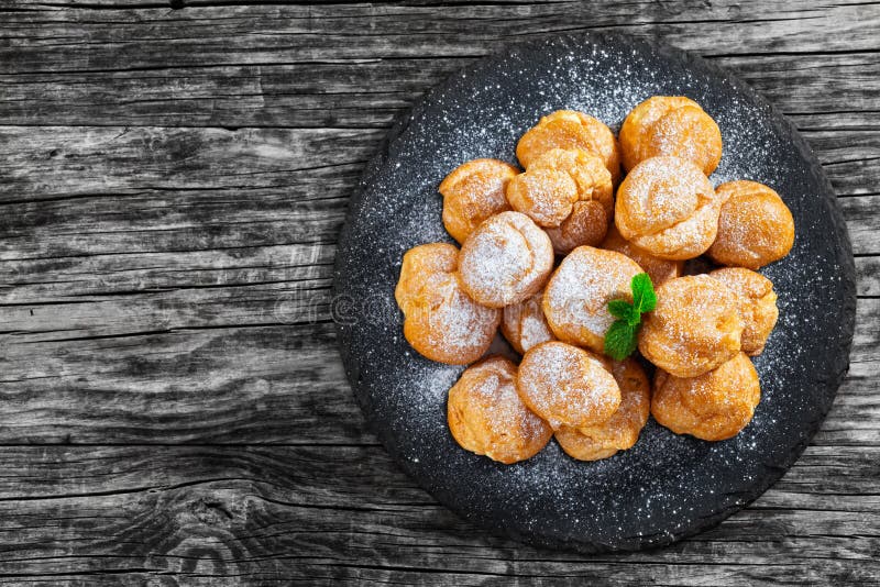 Heerlijke die profiteroles met room op lei wordt gevuld plat stock foto Heerlijke die profiteroles met room op lei wordt gevuld plat stock foto
